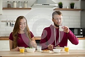 Young attractive couple having healthy breakfast dining together