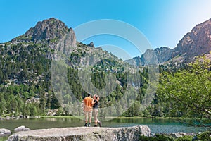 Young Attractive Couple holding hands in a Beautiful Lake in the mountains in summer during sunset. Discovery Travel