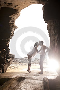 Young attractive couple kissing through rock archway