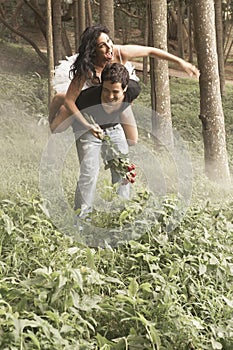 Young attractive couple laughing and flirting in the woods