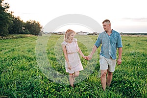 Young attractive couple in love in summer day in field