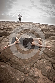 Young attractive couple outdoors on beach rocks