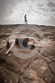 Young attractive couple outdoors on beach rocks