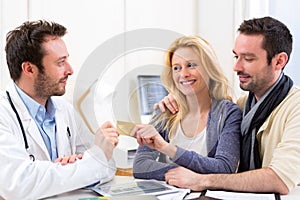 Young attractive couple paying consultation to the doctor