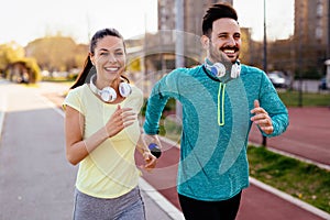 Young attractive couple running outside on sunny day