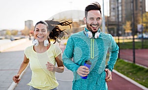 Young attractive couple running outside on sunny day