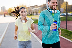 Young attractive couple running outside on sunny day