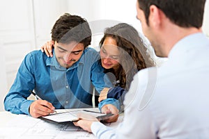 Young attractive couple signing contract photo