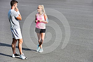 Young attractive couple talking in the road after jogging