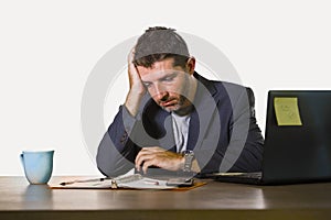Young attractive depressed and frustrated businessman working at office computer desk desperate and overwhelmed feeling upset