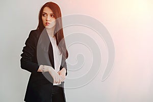 Young attractive emotional girl in business-style clothes on a plain white background in an office or audience