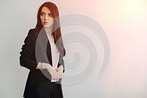 Young attractive emotional girl in business-style clothes on a plain white background in an office or audience photo