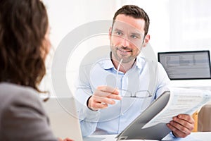 Young attractive employer analysing resume of woman