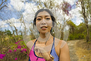 Young attractive and exotic Asian Indonesian runner woman in jogging workout outdoors at countryside road track nature running