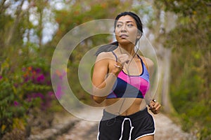 Young attractive and exotic Asian Indonesian runner woman in jogging workout outdoors at countryside road track nature running