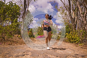 Young attractive and exotic Asian Indonesian runner woman in jogging workout outdoors at countryside road track nature running