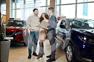 Young attractive family buying a new luxury car