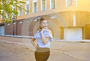 Young attractive fashion model posing on camera in a bright sunny day outdoor.