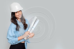 Young attractive female architect with white helmet