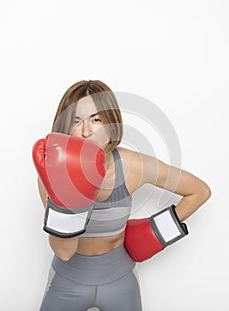 Young attractive female boxer in boxing gloves hitting on camera