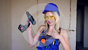 Young attractive female builder or worker showing thumbs up