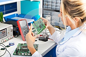 Female electronic engineer checking circuit board in laboratory