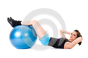 Young attractive female exercise using blue ball