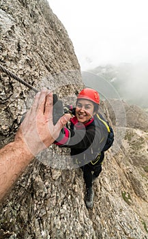 Joven atractivo una mujer montana alpinista en dolomitas de dar alto cinco éxito 