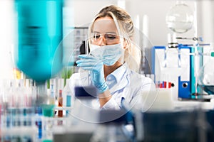 Young attractive female scientist preparing laboratory equipment