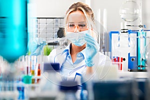 Young attractive female scientist preparing laboratory equipment