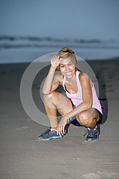 Young attractive and fit Asian sport runner woman running on beach sea side looking tired and happy smiling while hard workout