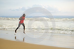 Young attractive fit athletic and strong black African American man running at the beach training hard and sprinting on sea water