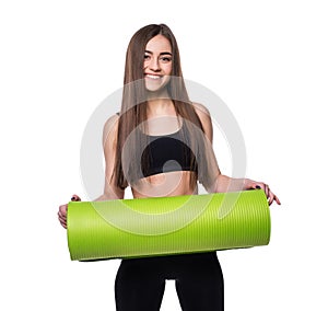 Young attractive fitness woman ready for workout holding green yoga mat isolated on white background.