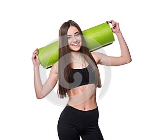 Young attractive fitness woman ready for workout holding green yoga mat isolated on white background.