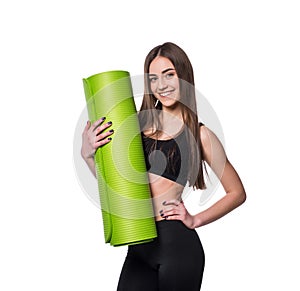 Young attractive fitness woman ready for workout holding green yoga mat isolated on white background.