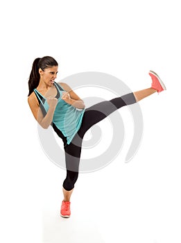 Young attractive and furious latin sport woman in fight and kick boxing training workout throwing aggressive kick attack