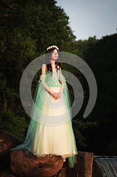 Young attractive girl dressed as fairy in evening garden