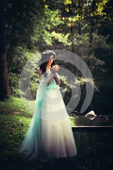 Young attractive girl dressed as fairy in evening garden