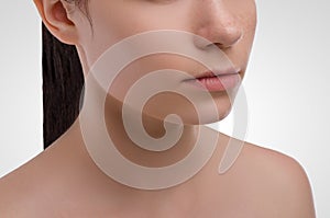 Young attractive girl face detail on a white background. Healthcare. Beautiful woman.