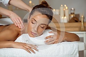 Young attractive girl having massage relaxing in spa salon.