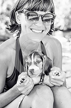 Young attractive girl with her pet dog Beagle at the beach of tropical island Bali, Indonesia. Happy moments. Black and