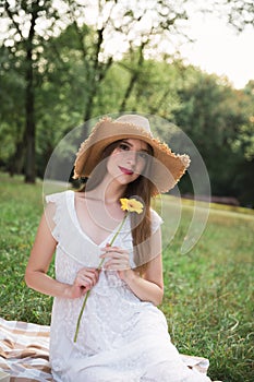 Young attractive girl holds a summer wildflower