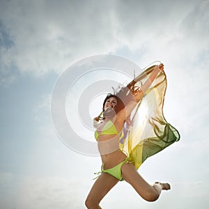 Young attractive girl jumping with Brazil flag in the air