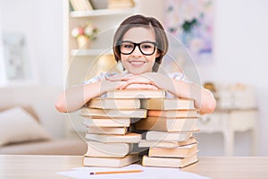 Young attractive girl is leaning on pile of books