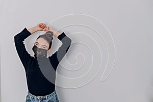 Young attractive girl on a light background wears a medical mask. use of personal protection. anti-epidemic and anti-pollution