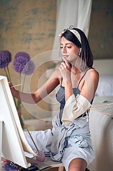Young attractive girl painter getting inspiration from music