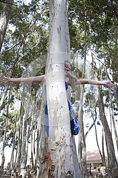 A young attractive girl playing hide and seek in the woods