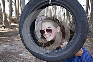 A young attractive girl playing with a tyre swing