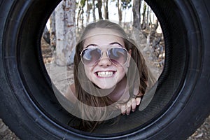 A young attractive girl playing with a tyre swing