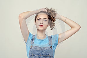 Young attractive girl raised hair with hands up. Nice smile. Den